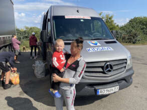 Mother and child prepare to board a bus to escape