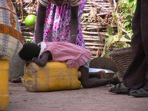 Little girl exhausted and asleep on a jerry can.