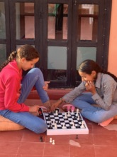 The new girls play chess on the rooftop