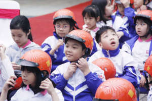 A student follows a helmet-wearing demonstration.