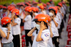 Students learning how to wear helmets correctly