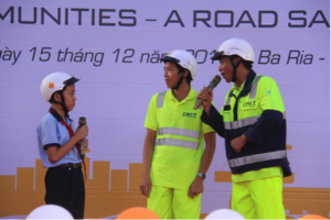 Truck drivers teach a student about helmet safety.