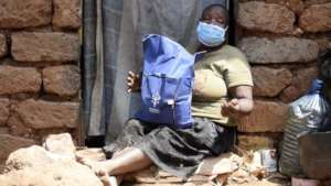 An elderly woman receives a food pack at her home