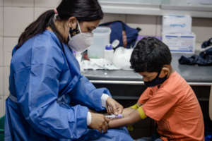 Health: collecting blood sample to student