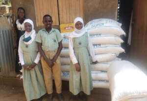 Students smile in front of a food delivery