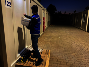 Volunteer distributes stoves at temporary shelters