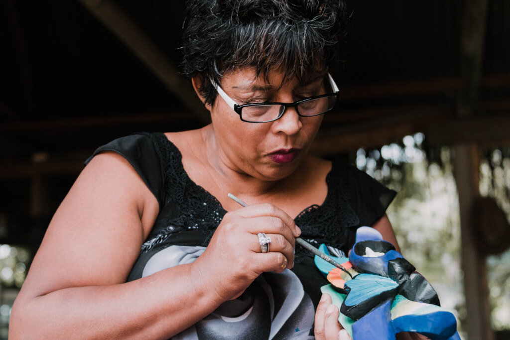 Mrs. Lourdes painting a mask