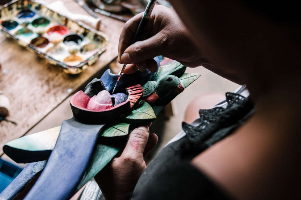 Mrs. Lourdes painting a mask