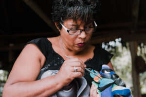 Mrs. Lourdes painting a mask