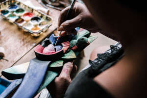 Mrs. Lourdes painting a mask