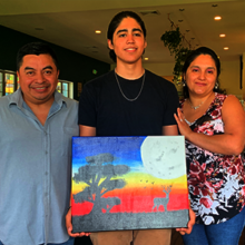 Teen artist with proud parents at recent exhibit
