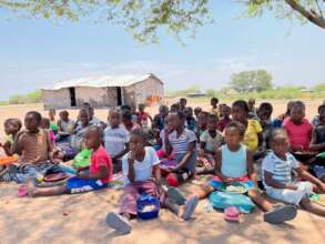 Students in the shade having lunch at Chate School