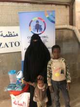 Mariam and her kids receiving hygiene kit