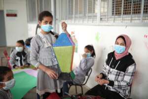 Nermeen and child make a lantern together