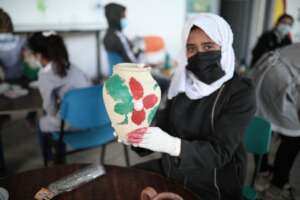 A child shows of her pottery project