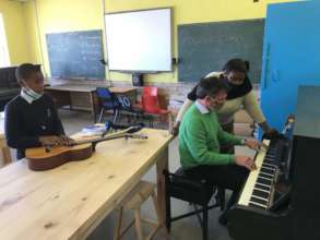 Mrs Mak and Mr Goulding playing the piano