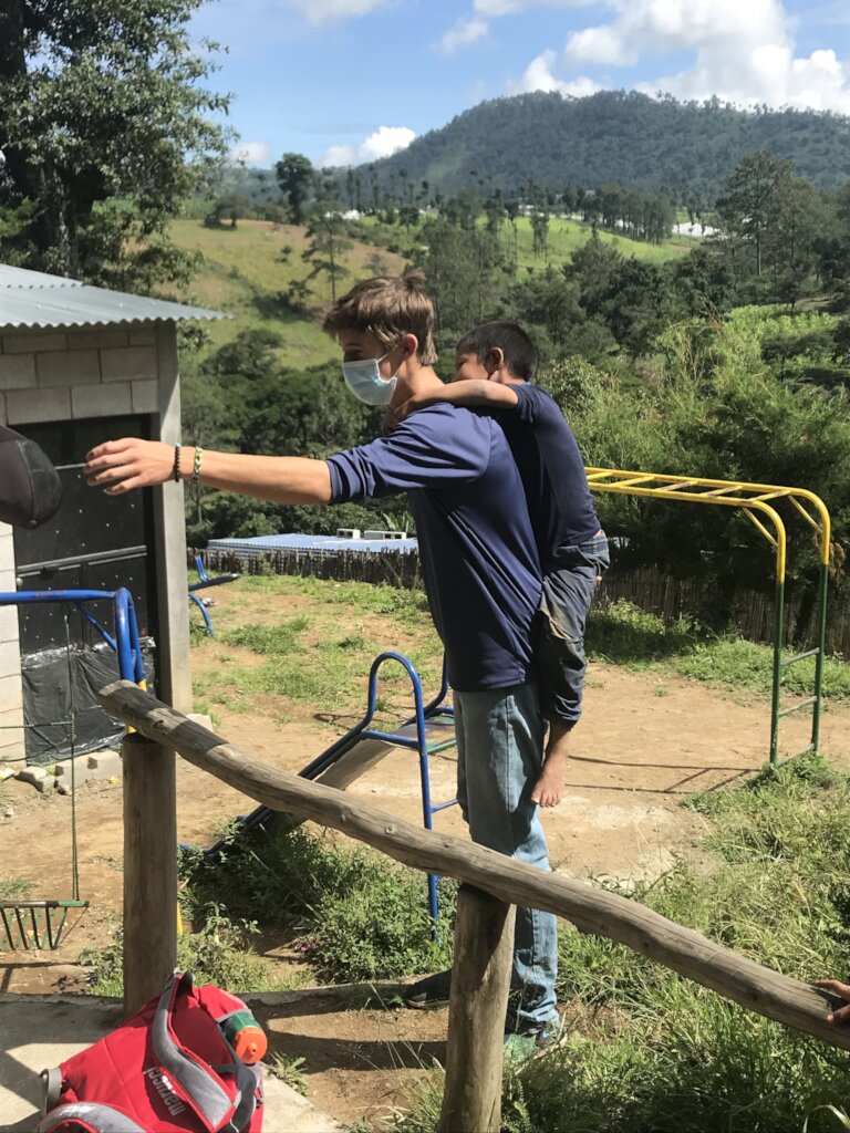 GL student playing with child in Segunda Cruz