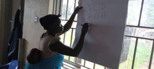Mary practicing how to write letters of Alphabet