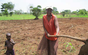 A farm worker in Uganda with her child