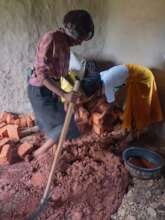 Getting stuck in mixing mud to build the stove