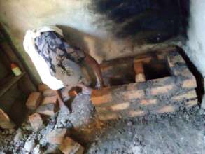 Rehema constructs the walls of the stove