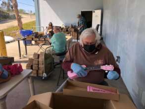 Volunteer Tuning Angels Prep Ukes for Kids at Home