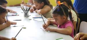 Young children concentrate on writing their names