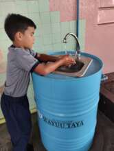 A child trying a handwashing station.