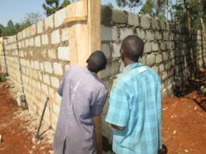 Construction workers inspecting the cinder wall