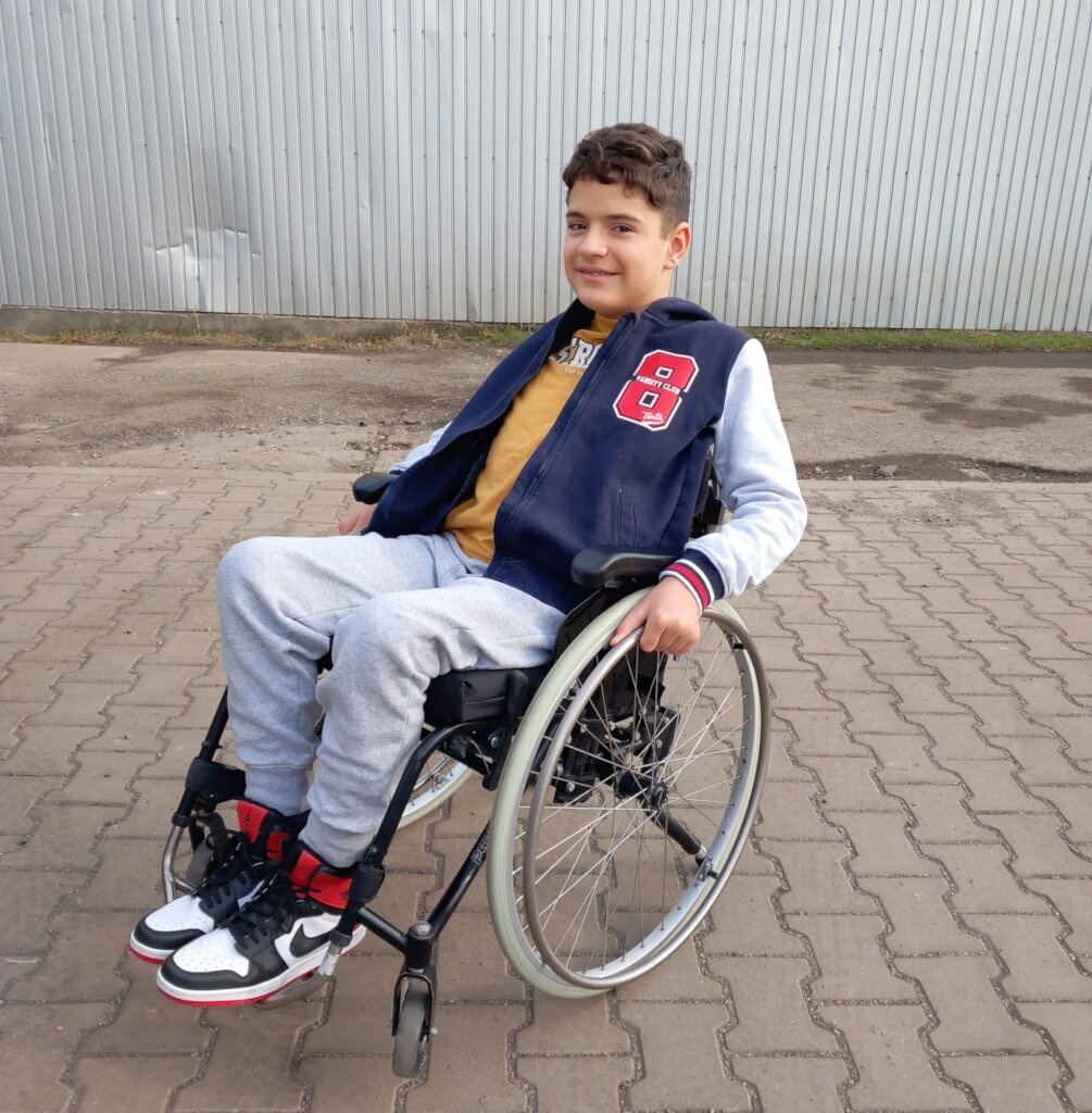 David doing his first wheelie in a new wheelchair