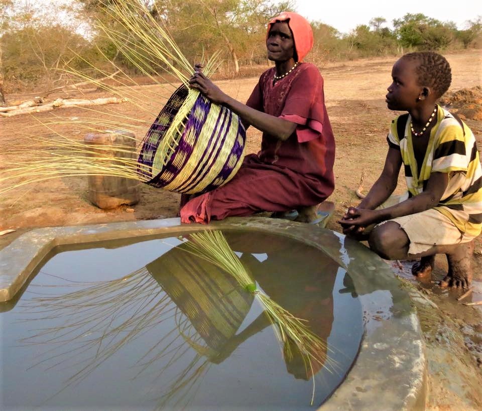 Women softening reeds at well