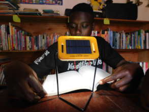 One of the MULIA child reading a book with solar