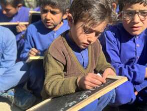 A kid writes on mini Chalkboard in District Kurram