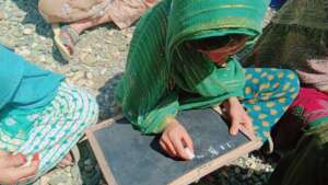 A girl writes on Mini Chalk Board at Dosti School