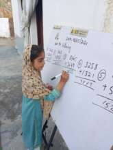 Girl solving math on outdoor whiteboard