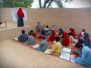 Outdoor village class with teacher and kids