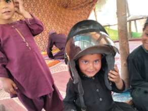 Child smiling in helmet under dosti school tent