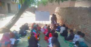 Outdoor class under tree with many students