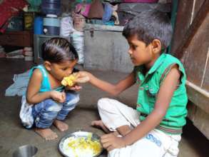 Boy feeding his sibling