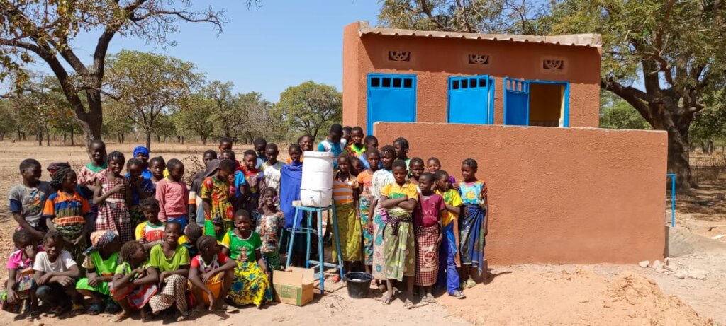 Primary school girls in front of the tiled latrine
