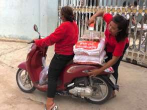 Raeksmey (right) loads a motorscooter
