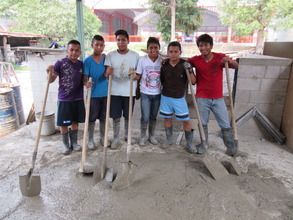 Members of the youth group help pour cement blocks