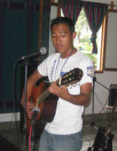 Juan Carlos plays guitar at a talent show.