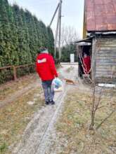 Volunteer brings food package to older lady.Alytus