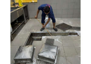 Kitchen staff cleaning the drain