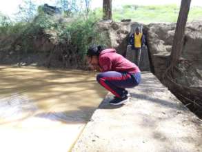 Hifadhi Africa Staff Drinks Water from Sand Dam