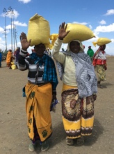 Women carrying maize bags on their head going home