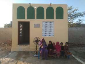 Happy family sitting in front of their new home