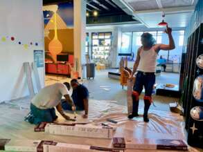 Volunteers install flooring in the music corner