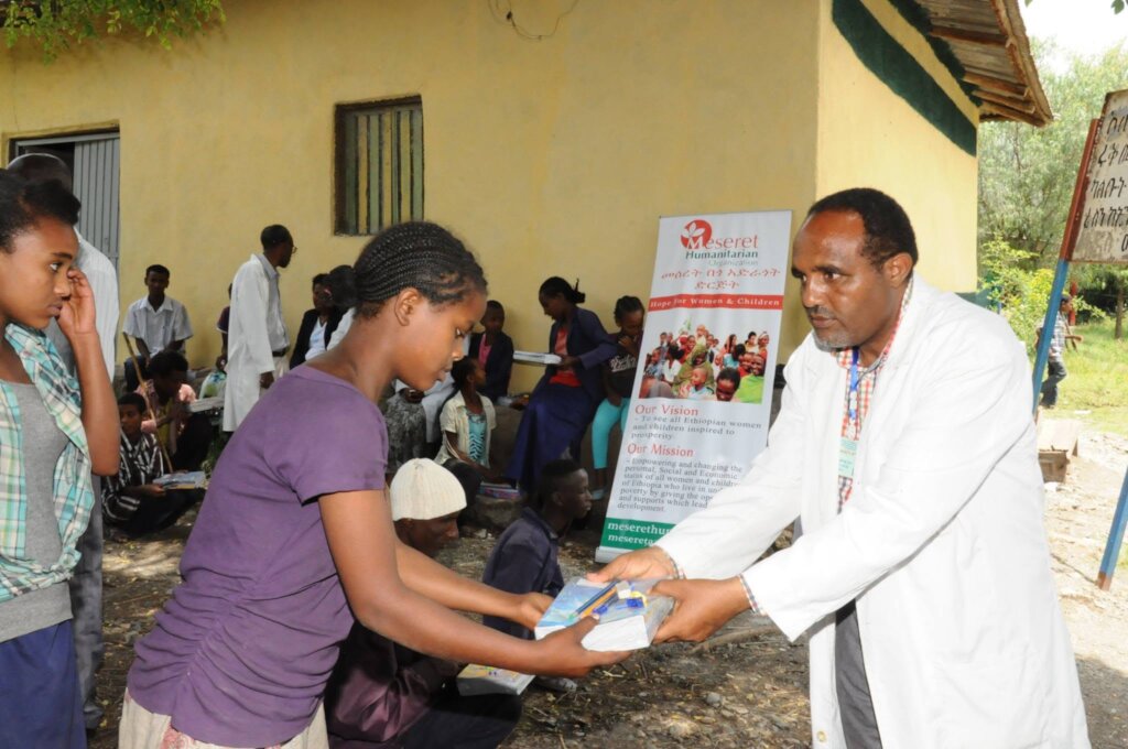A partial view of girl receiving educ materials
